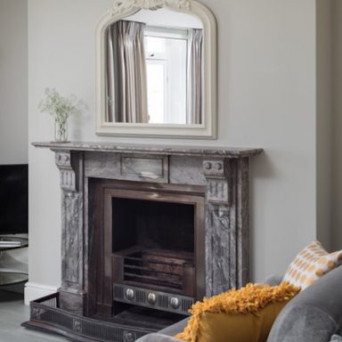 the georgian townhouse living room with fireplace and mirror