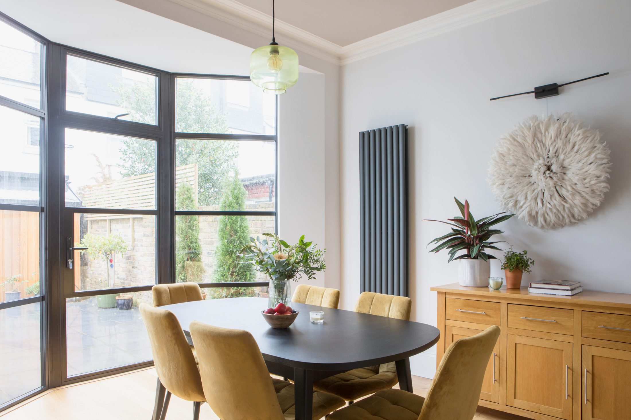 Contemporary dining room in a Brighton home with Crittall-style glazing and mustard dining chairs