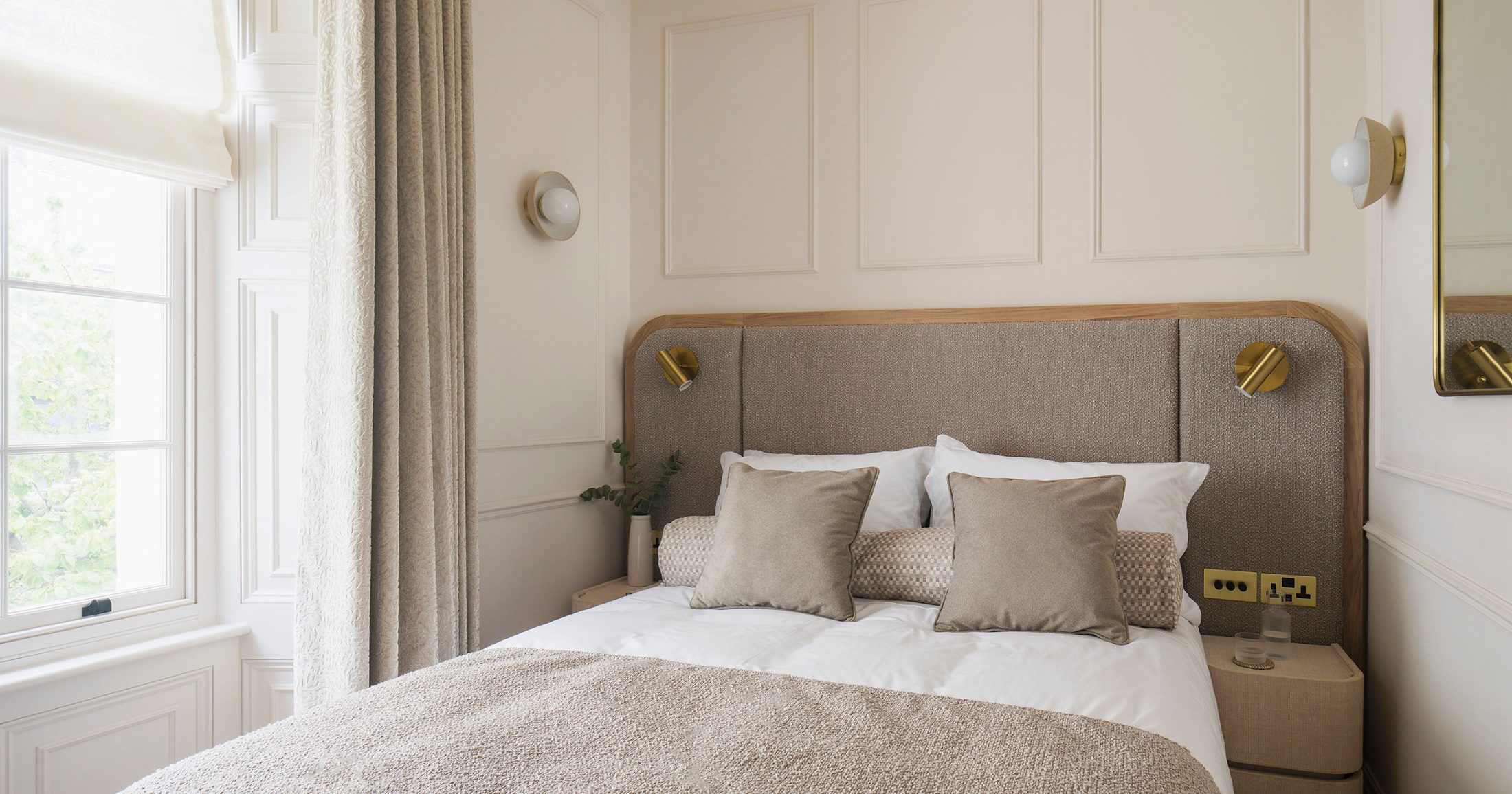 Elegant period bedroom interior in Brighton with bespoke upholstered headboard and period architectural detailing