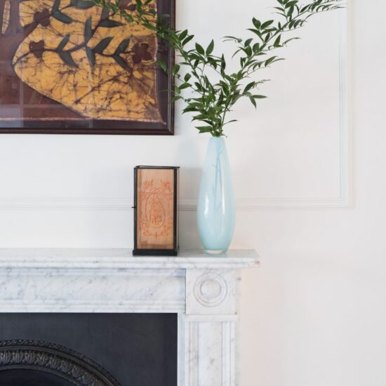 Period fireplace and curated artwork in a Brighton home designed by Elixir Interior Design.